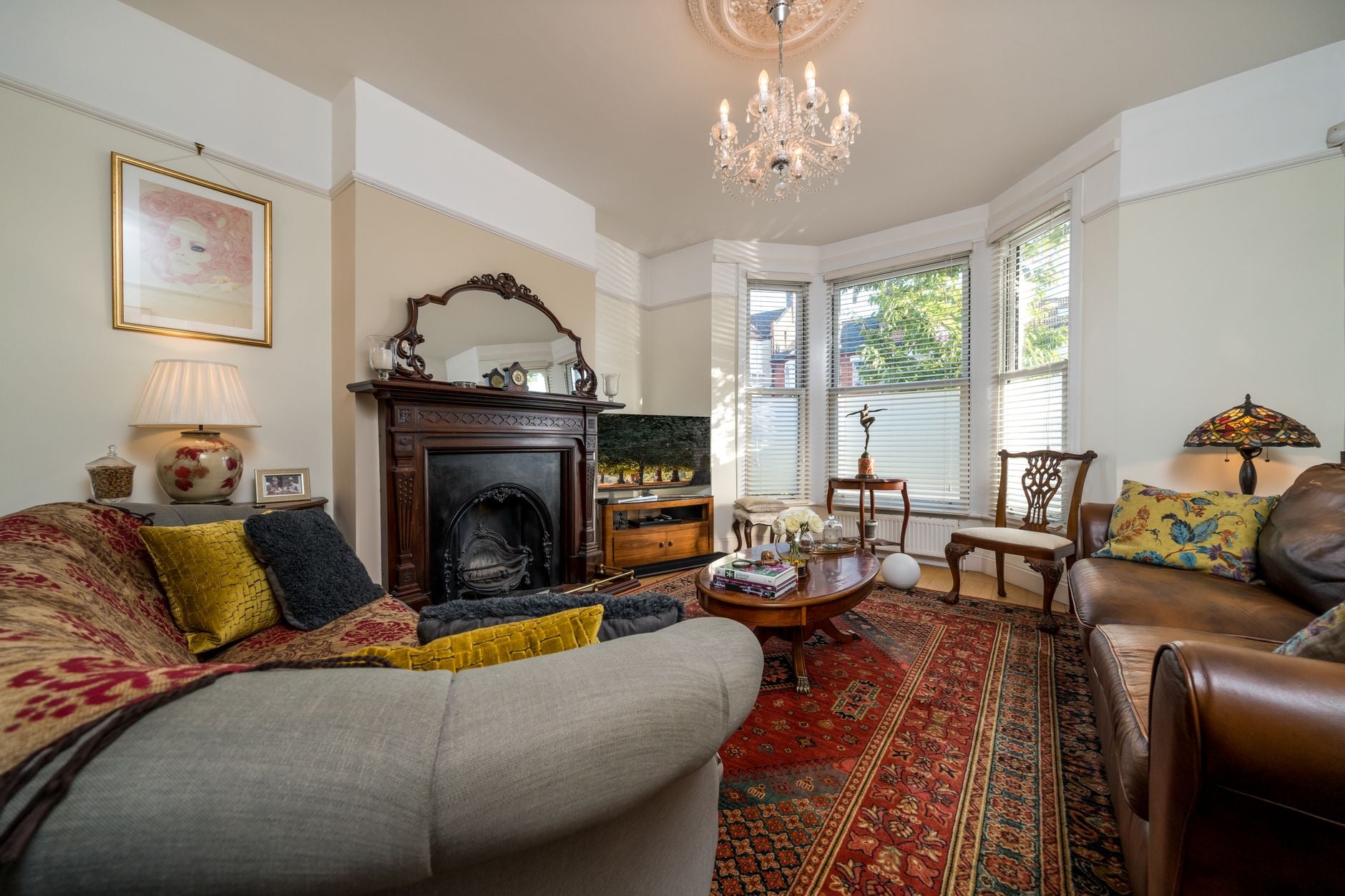 Charming living room with vintage decor, featuring plush sofas and a classic chandelier.